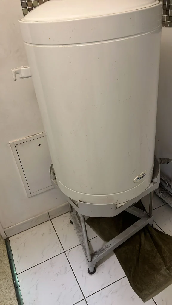 Ancien chauffe-eau sur trépied avant remplacement